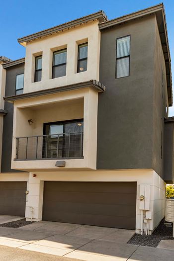 A modern two-story house with a balcony on the second floor.